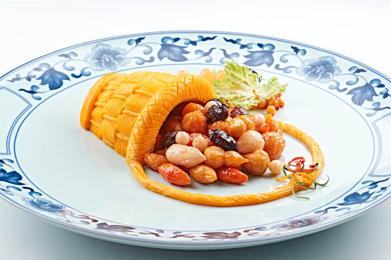 青花瓷盘装的精美雕刻摆盘的富贵花篮