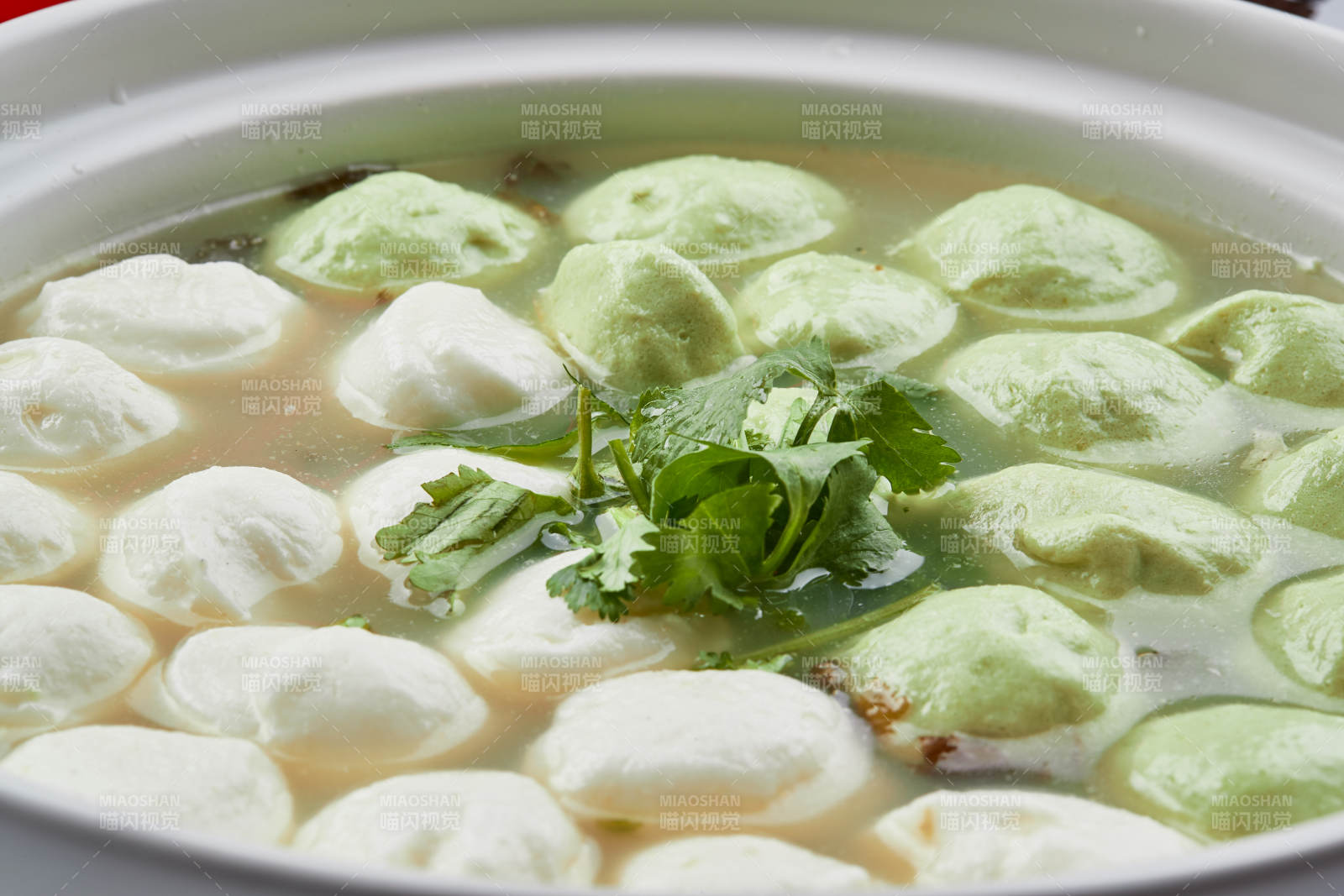 白色砂鍋裝的雙色手打魚丸