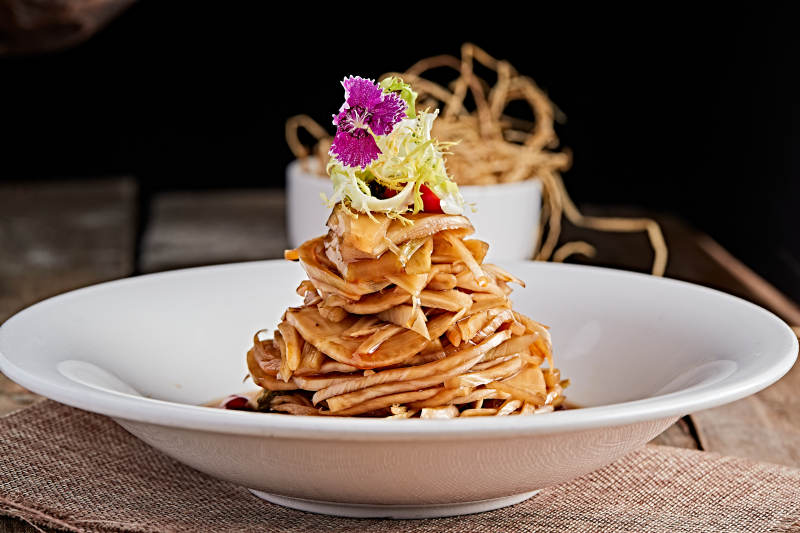 白色瓷盘装的醋腌萝卜皮