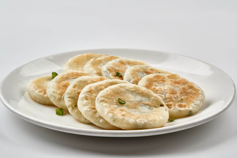 白色瓷盘装的现烙葱油饼