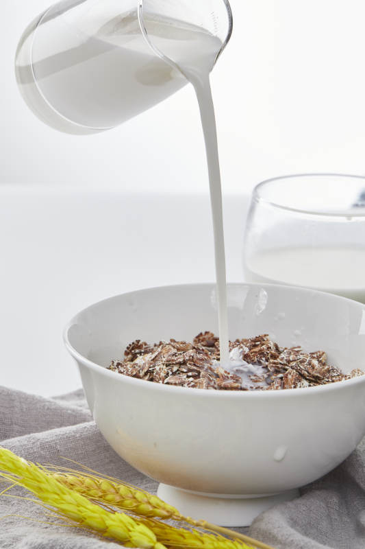 向装满低脂黑燕麦片的碗中倾倒牛奶