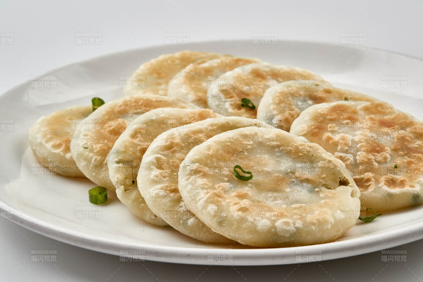 白色瓷盤(pán)裝的現(xiàn)烙蔥油餅
