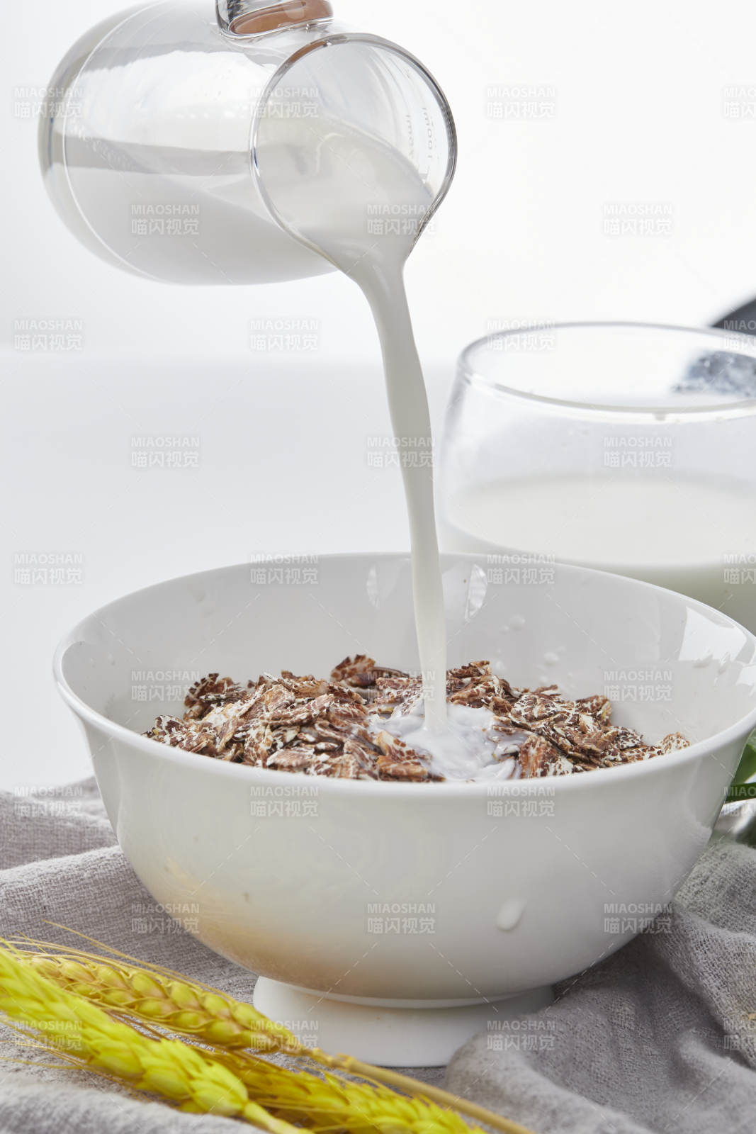 向裝滿低脂黑燕麥片的碗中傾倒牛奶