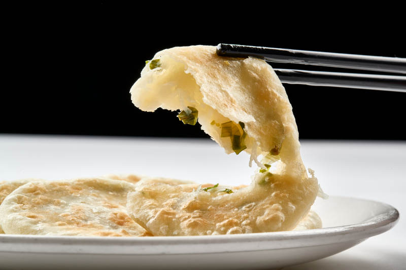 白色瓷盘装的现烙葱油饼