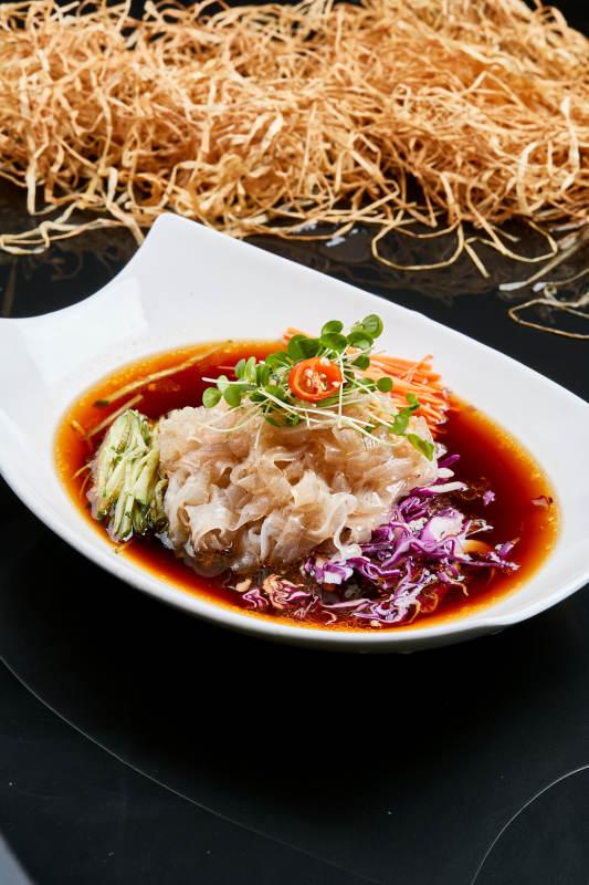 白色瓷盘装的浇汁时蔬山药大拉皮