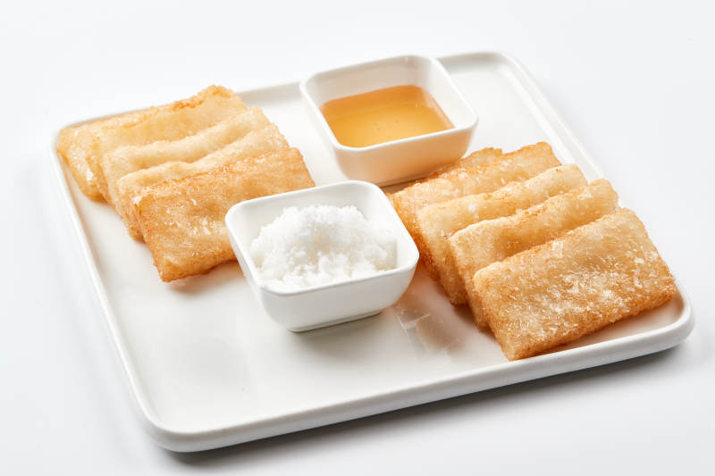 白色瓷盘装的美味香炸糯米糍粑