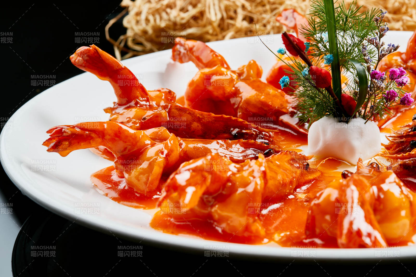 白色瓷盘装的浇汁油炸开背大明虾