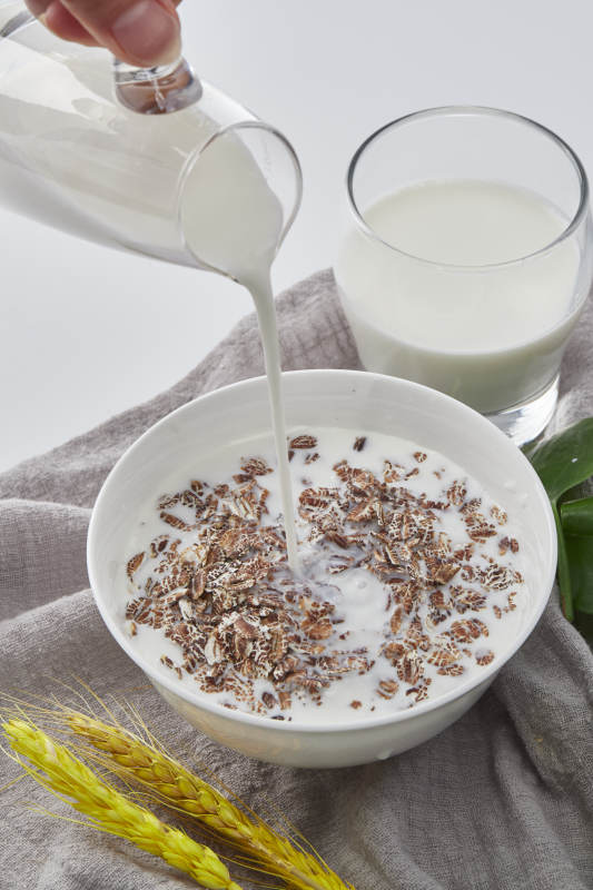 向装满低脂黑燕麦片的碗中倾倒牛奶