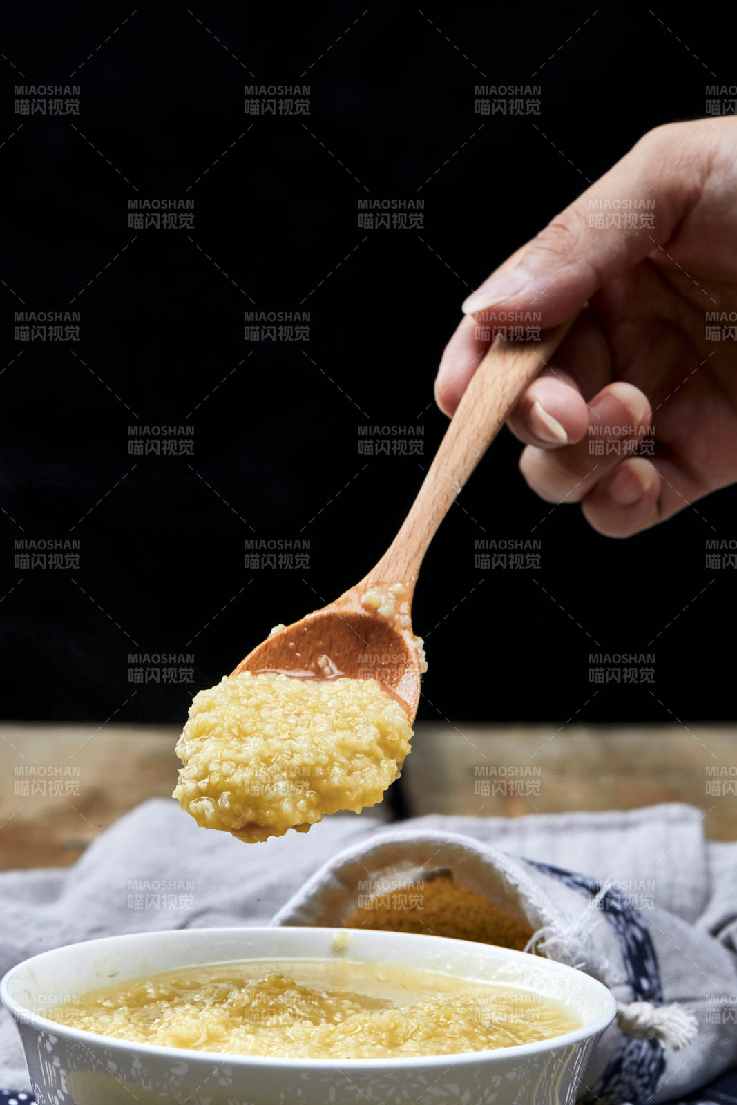 手持木勺㧟起的美味香浓小米粥
