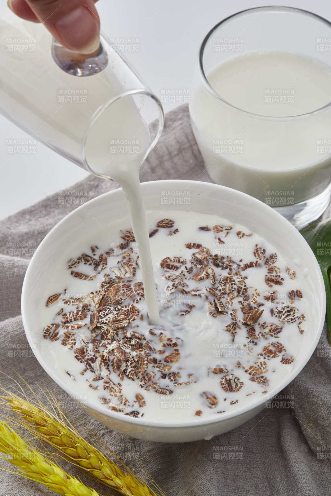向裝滿低脂黑燕麥片的碗中傾倒牛奶