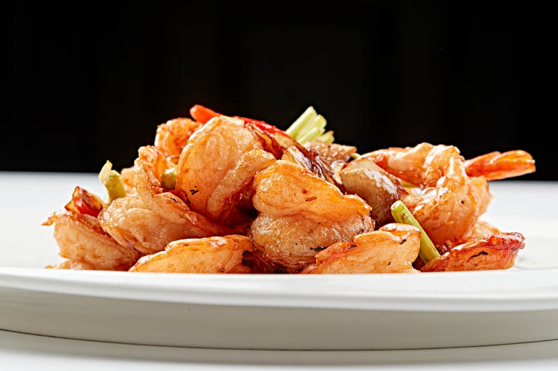 白色瓷盘装的甜辣油炸开背虾