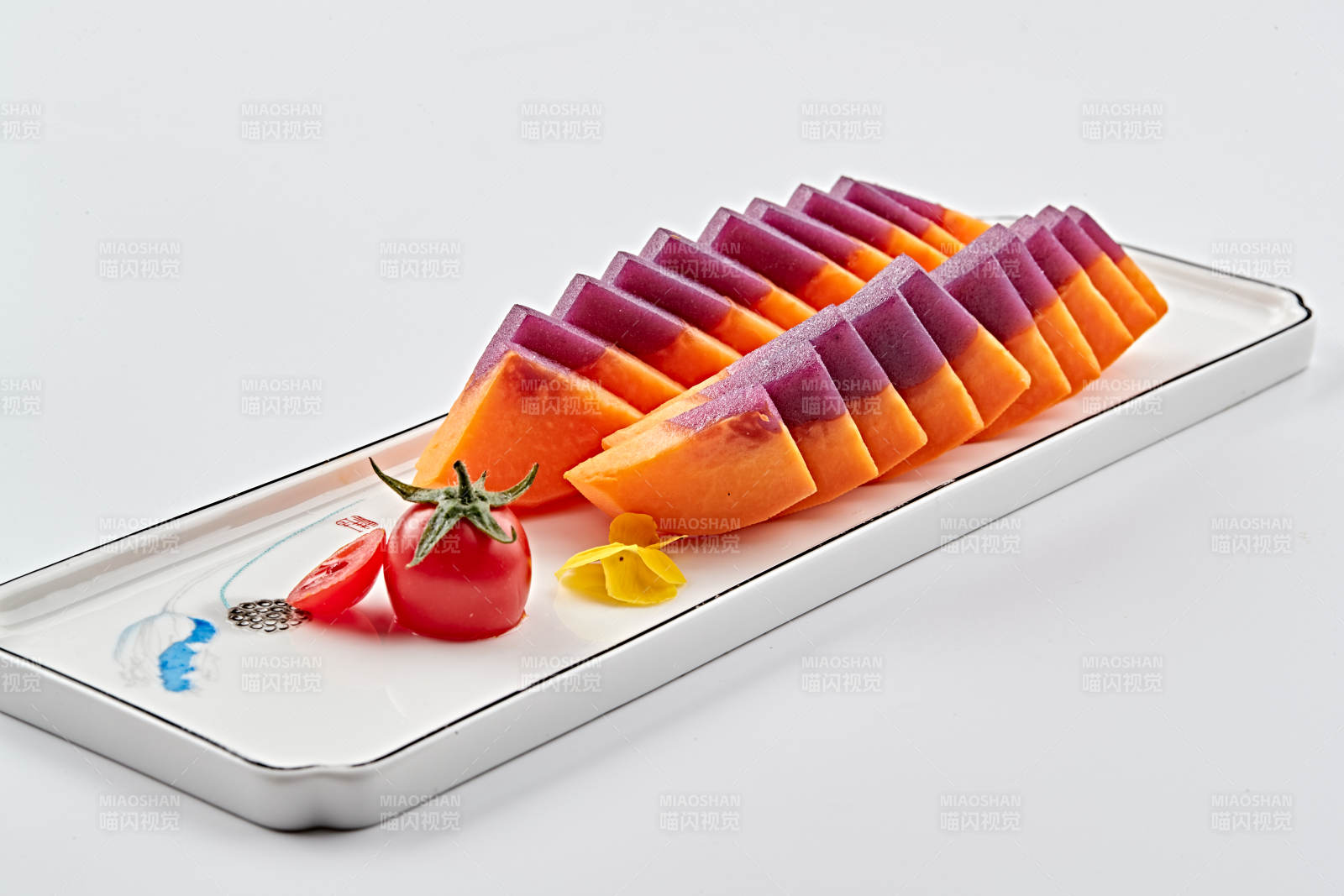 白色長瓷盤裝的涼菜紫薯木瓜