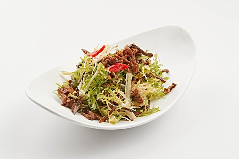 白色瓷盘装的苦菊炝拌茶树菇