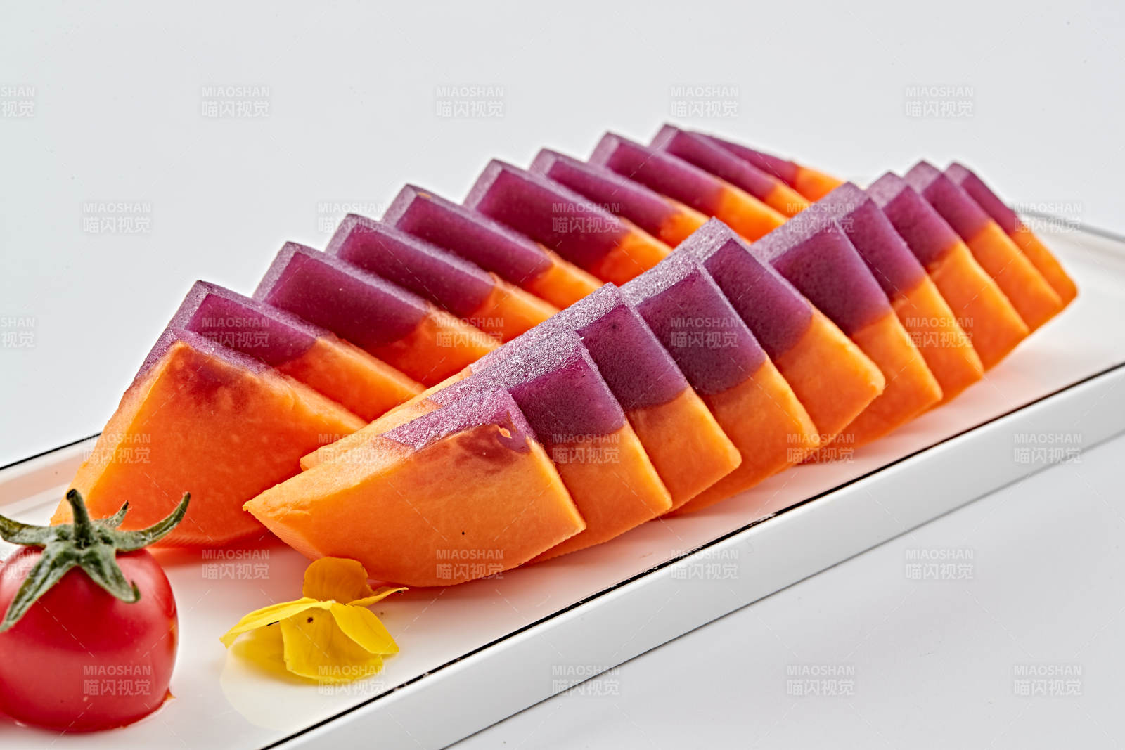 白色長瓷盤裝的涼菜紫薯木瓜