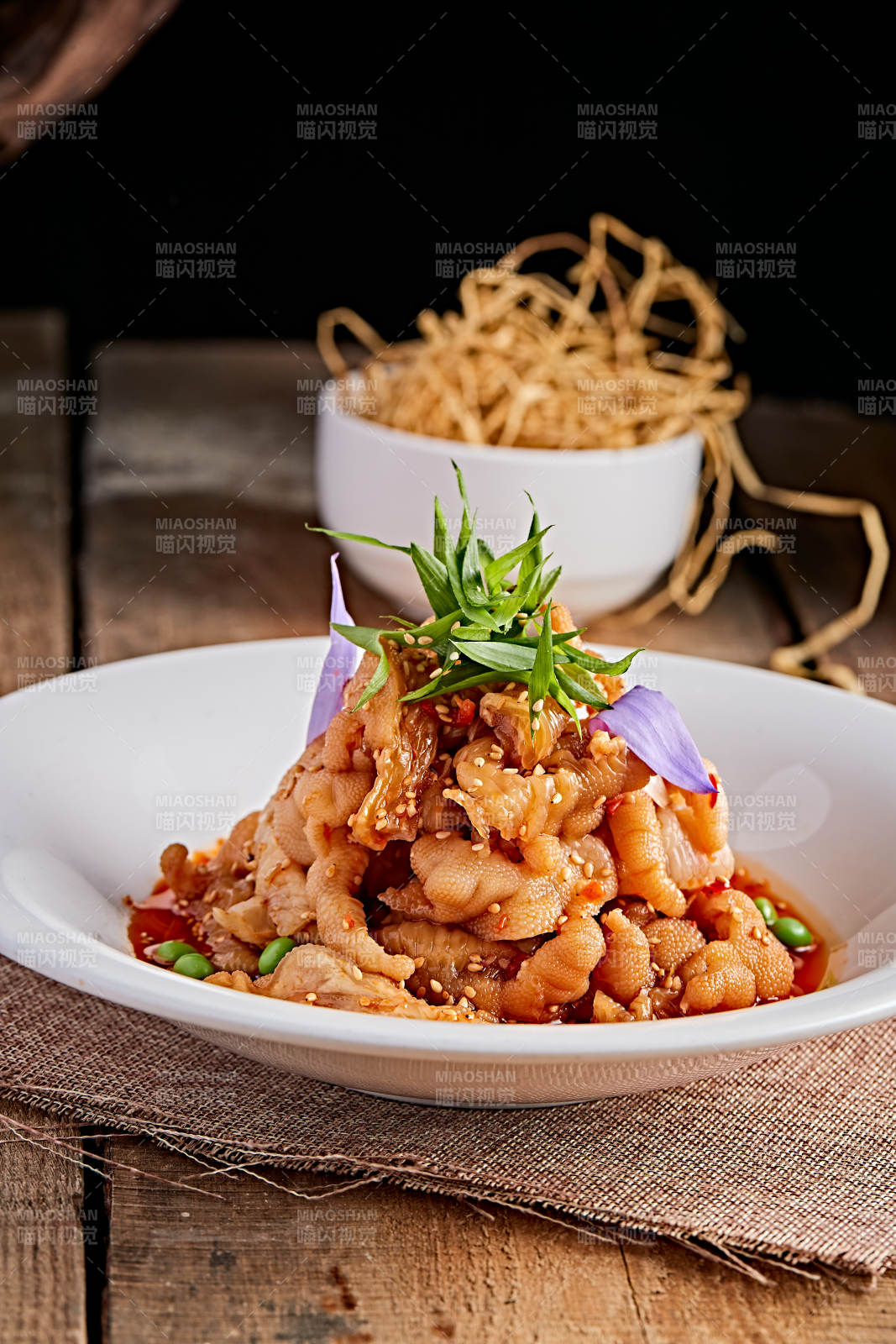 白色瓷盘装的红油酸辣脱骨凤爪