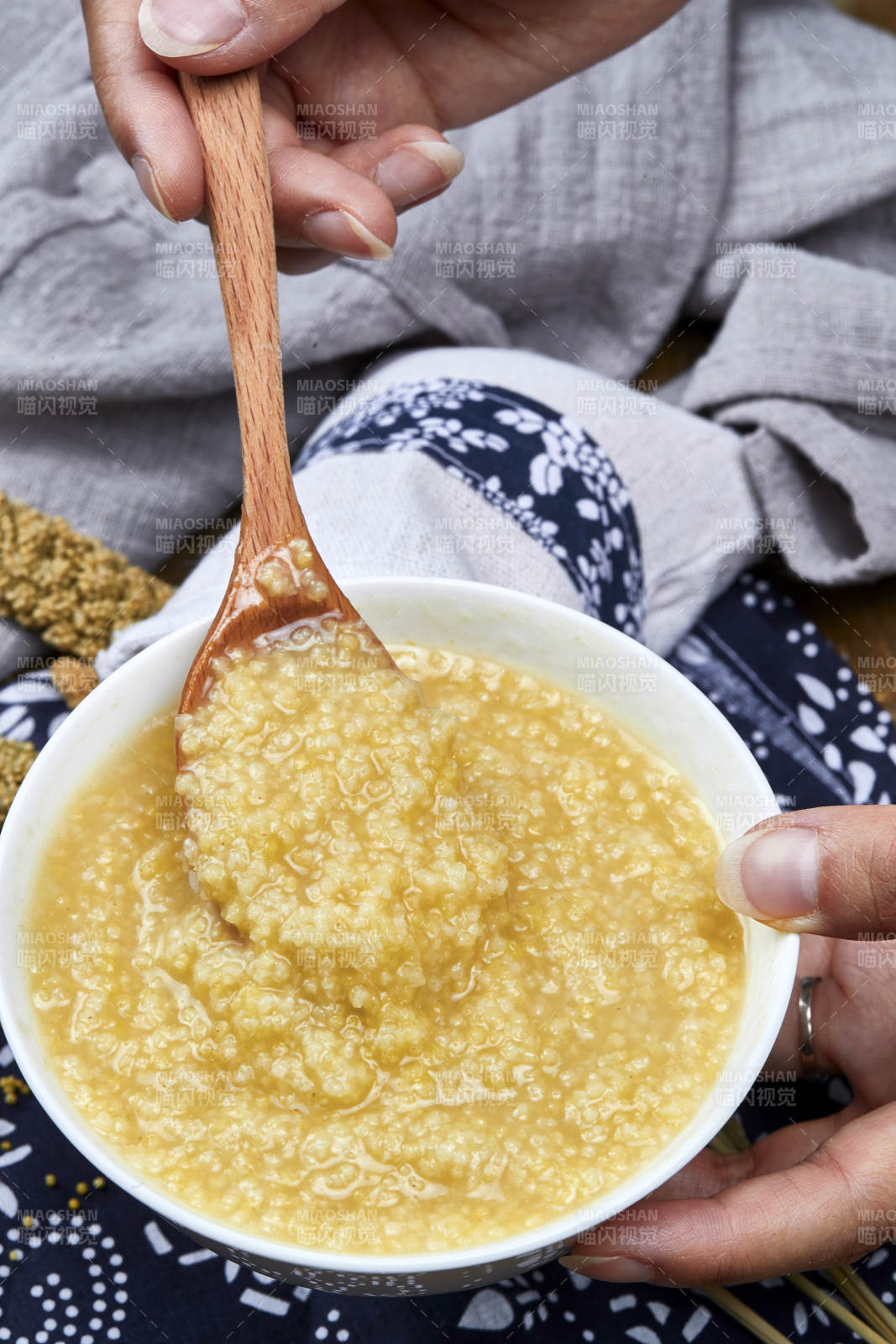 手持木勺㧟起的美味香浓小米粥