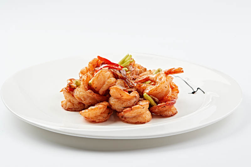 白色瓷盘装的甜辣油炸开背虾