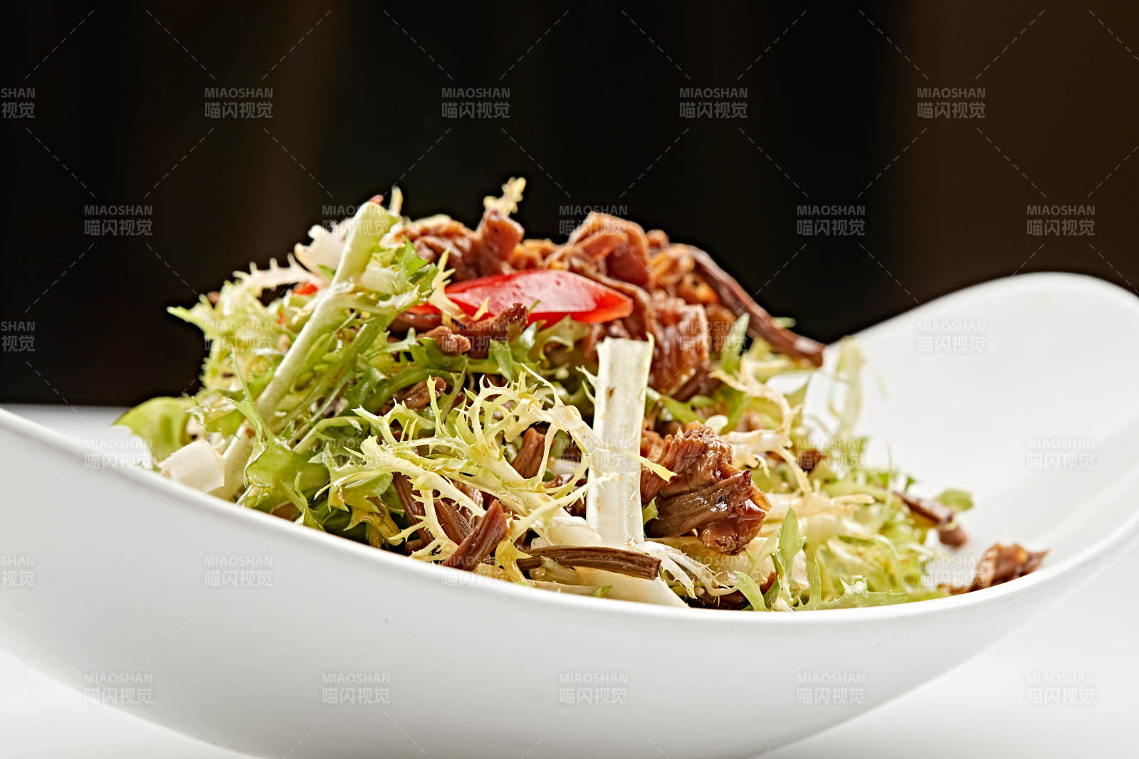 白色瓷盘装的苦菊炝拌茶树菇