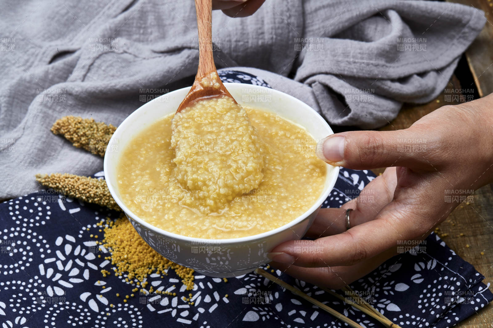 手持木勺㧟起的美味香浓小米粥