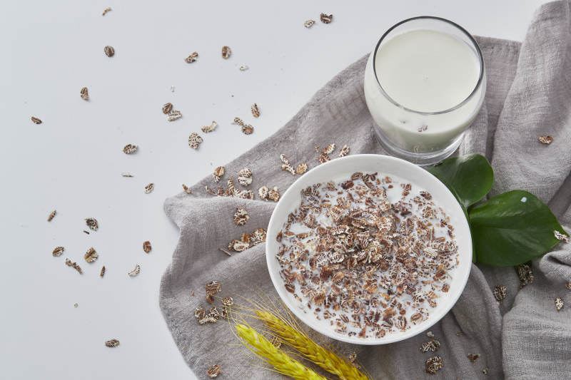 向装满低脂黑燕麦片的碗中倾倒牛奶