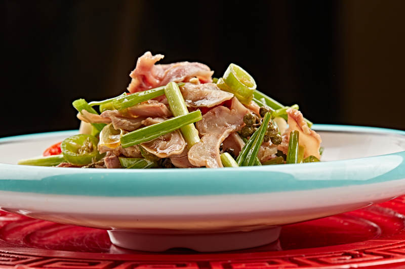 白色瓷盘装的苦菊炝拌茶树菇