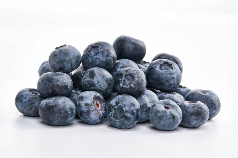 白色背景上摆放的水润新鲜蓝莓果