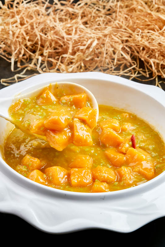 白色瓷餐具装的浓香青豆金米南瓜羹