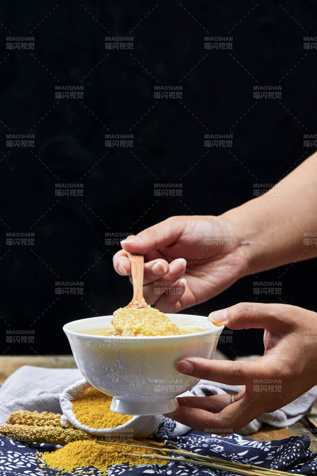 手持木勺㧟起的美味香浓小米粥
