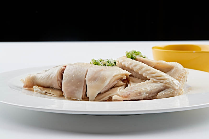 白色盘装的广式蘸汁白切鸡