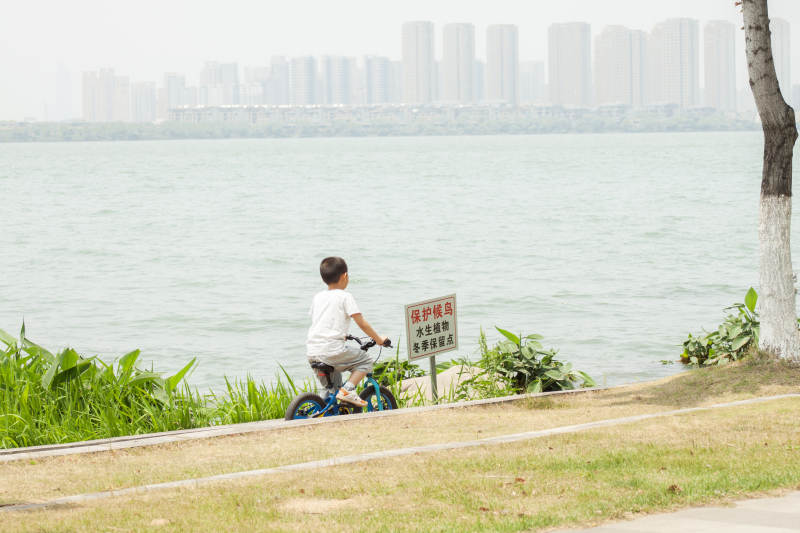 湖畔骑车的小孩