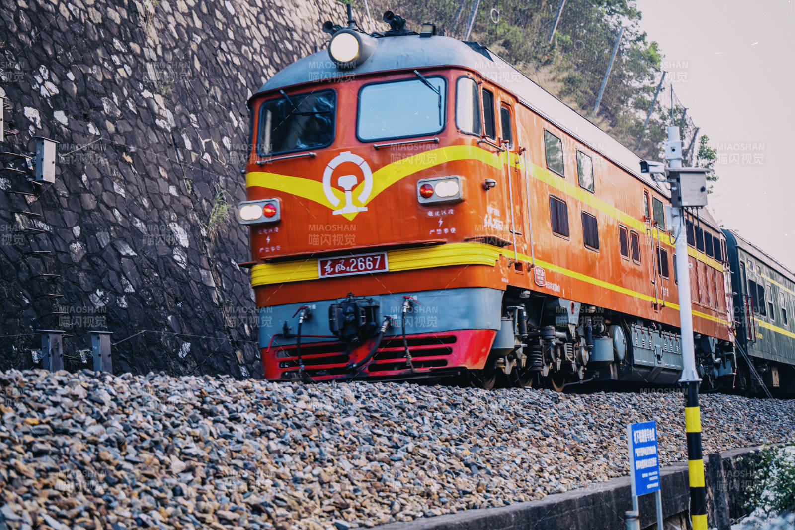 橙色火车穿行山间-摄影图