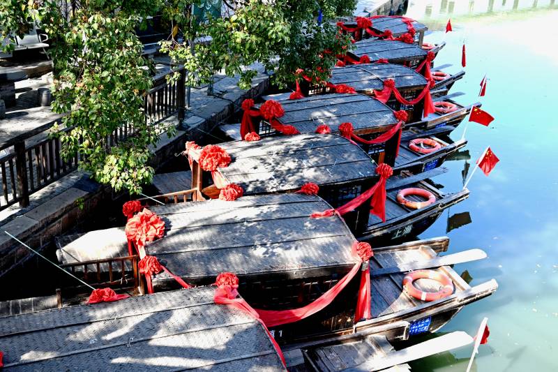 紅綢裝飾的古鎮市河游船