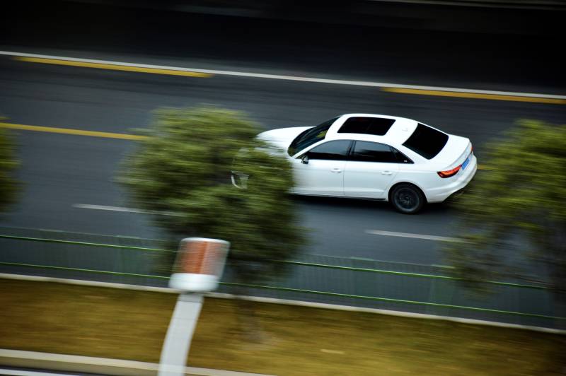 疾驰的白色轿车-摄影图