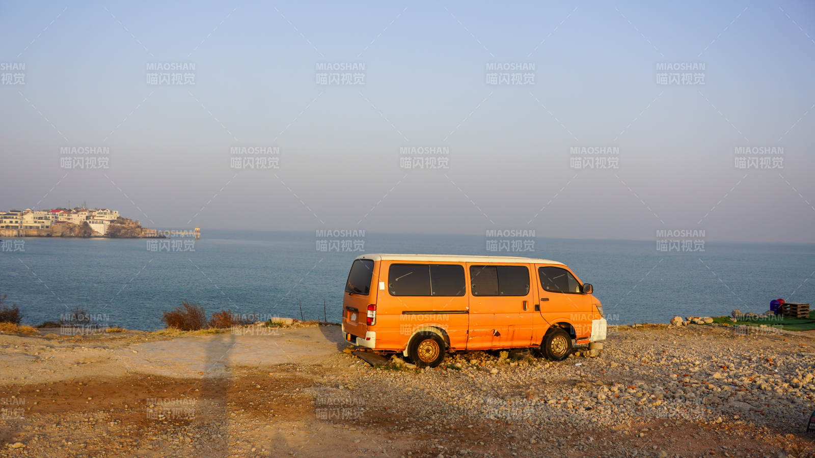 橙色面包車海邊停泊-攝影圖