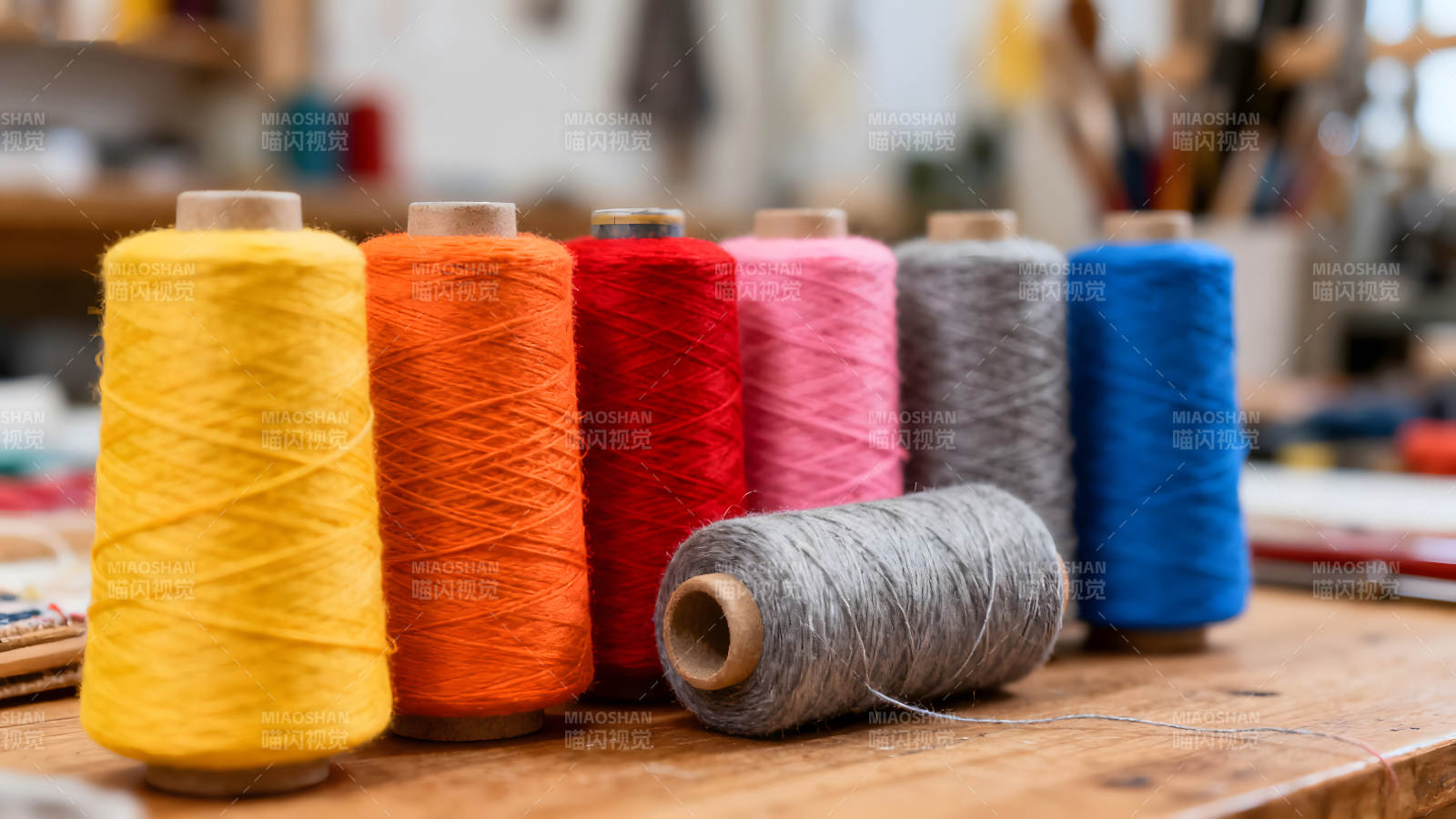 五彩线轴排列在木桌上-图片