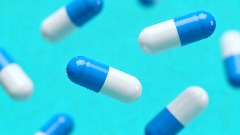 药丸悬浮在蓝色的背景上-图片