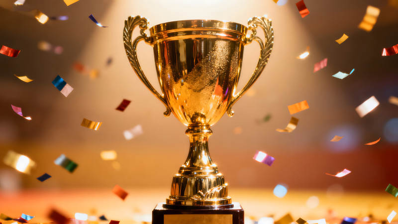 金色的奖杯和飘落的彩纸庆祝胜利-图片