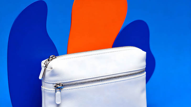 白色包包置于蓝色橙色背景上-图片