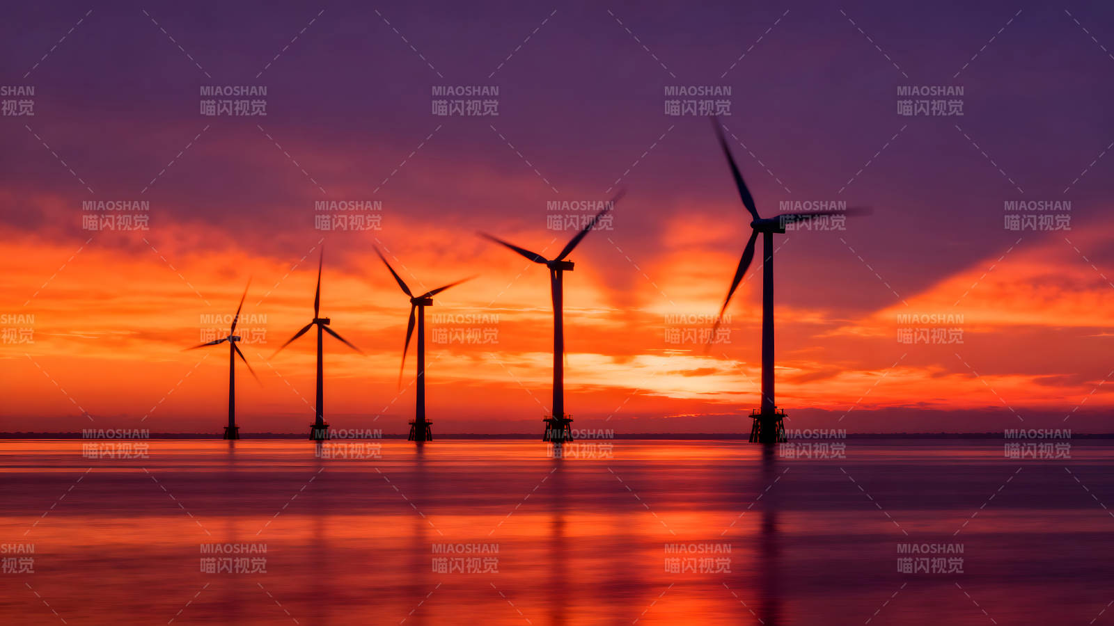 風車在海面上旋轉落日余暉照耀-圖片