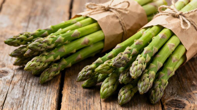 新鲜的芦笋捆绑在一起置于木板上-图片