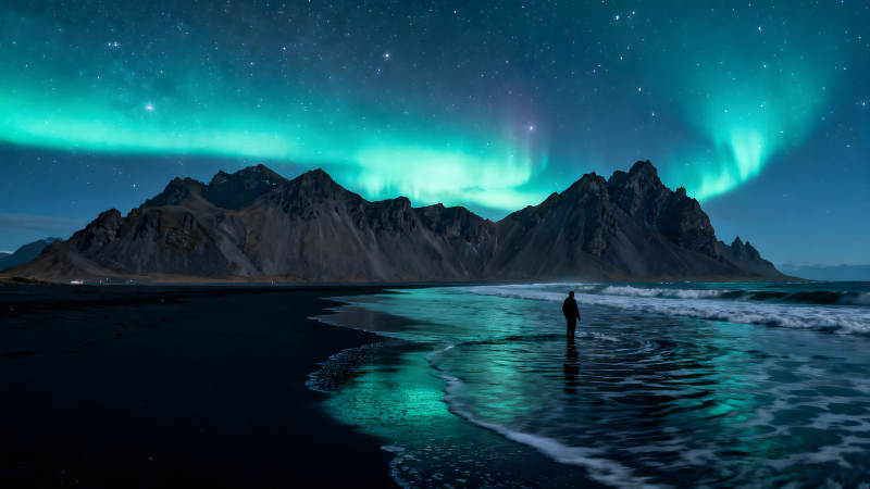 极光下的海滩与孤独的人影图片