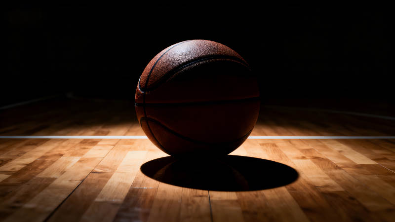 篮球在球场上光影下的特写-图片