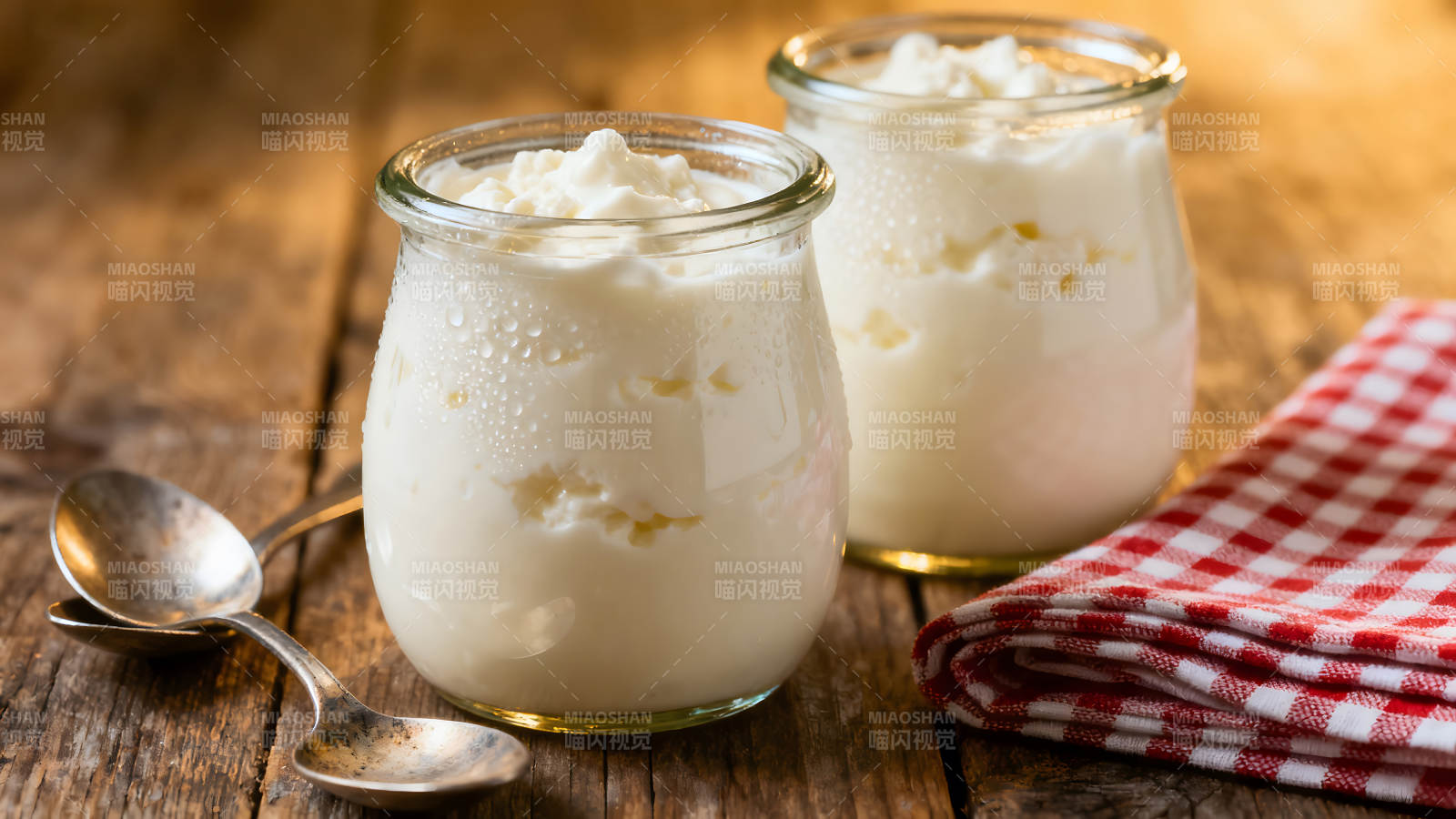 两杯酸奶放木桌上配勺子和餐巾-图片