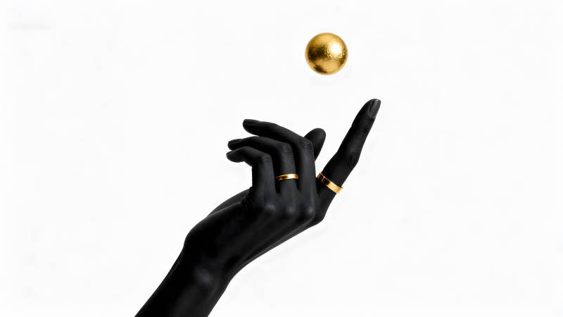 黑色手臂托举金色圆球-图片