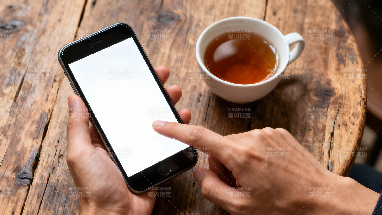 手機和茶杯在木桌上休閑時刻-圖片