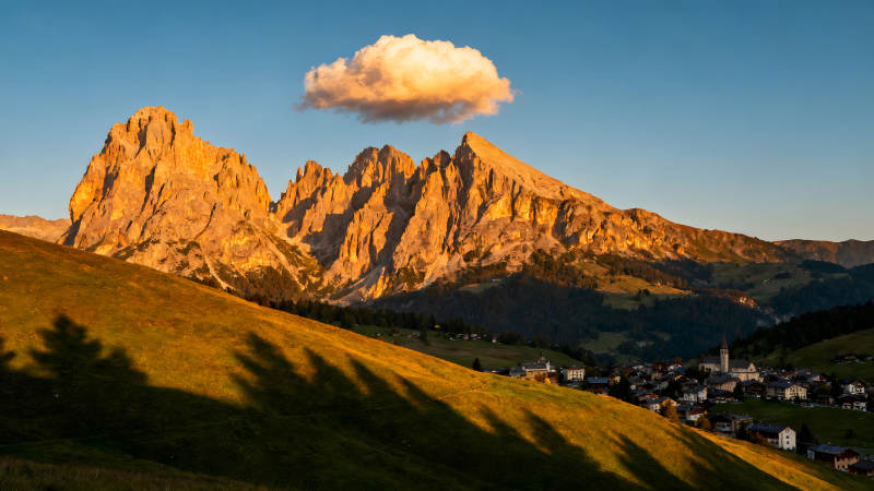 金色山峰下的村莊和云朵-圖片