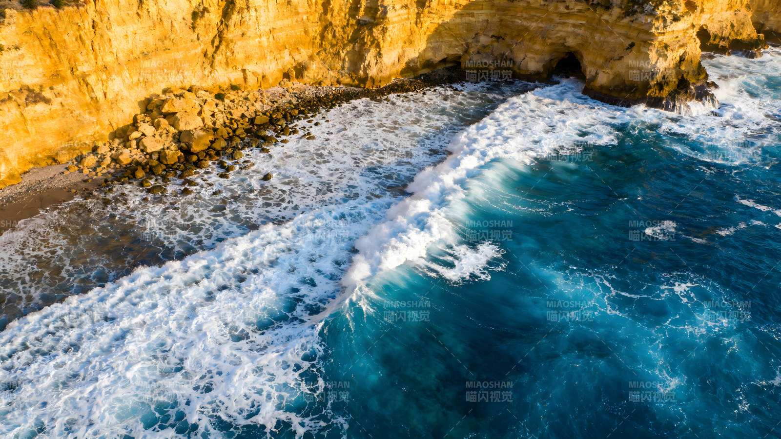 海浪拍打金黃懸崖景象圖片