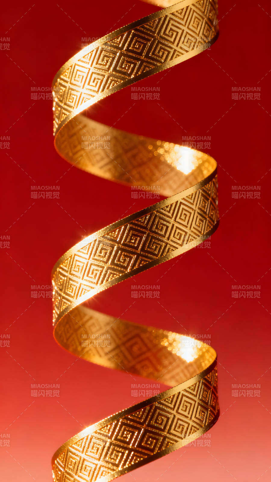金丝带在红色背景下旋转-图片