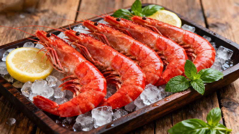 鮮蝦置于木盤上配以檸檬和薄荷-圖片