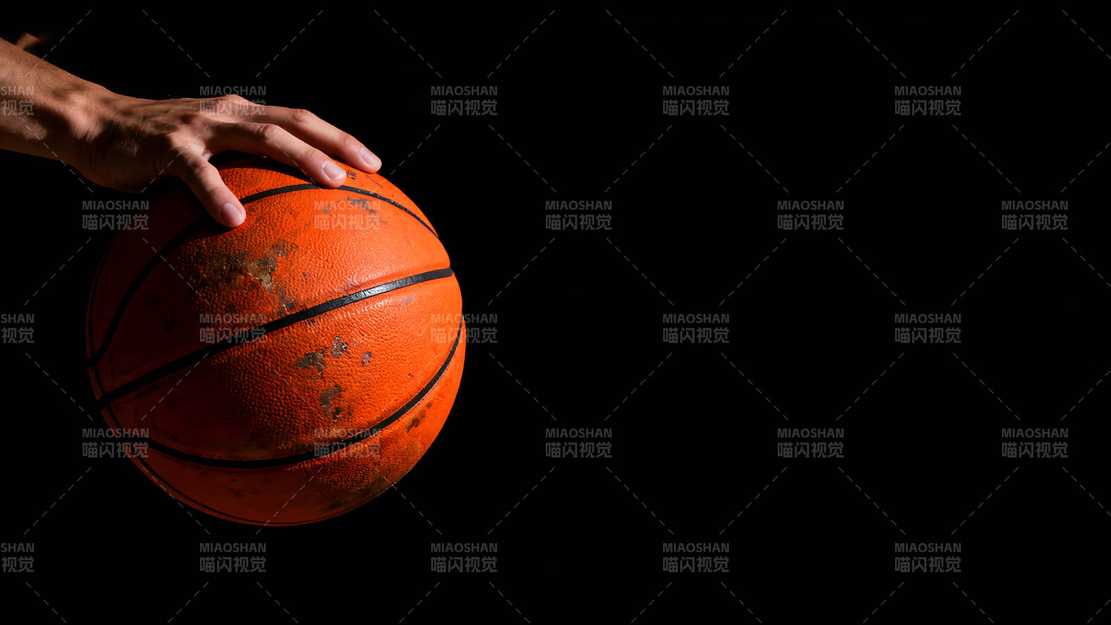 手握篮球黑色背景光线充足-图片